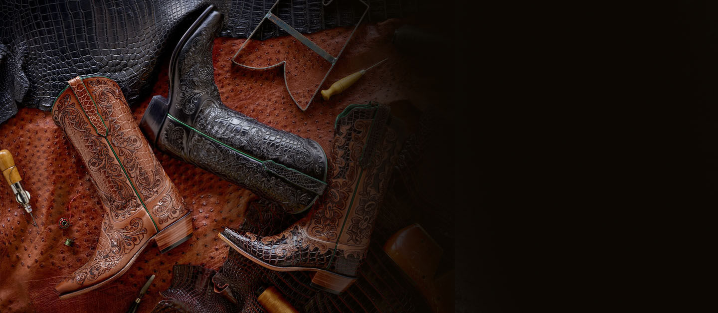 Custom black and brown tooled boots on leather hide.
